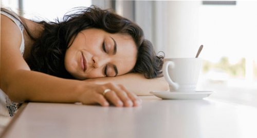 udmattet kvinde sover på bordet