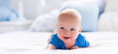 Smilende baby liggende på maven