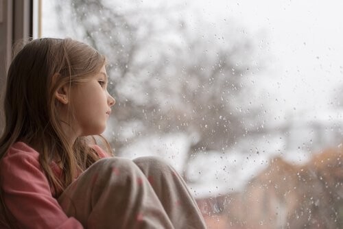 trist barn sidder i vindue