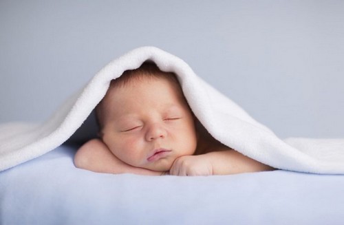 sovende baby krammer sin bamse