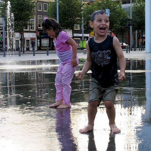 søskende leger i springvand