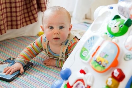 baby leger og kigger på kameraet