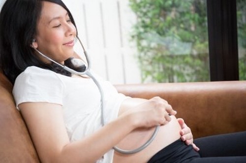 gravid kvinde lytter til sin mave