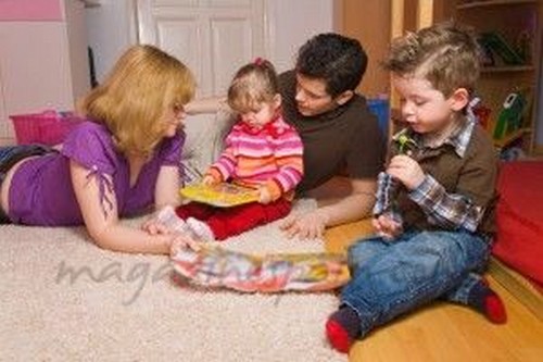 forældre leger på gulvet sammen med deres børn