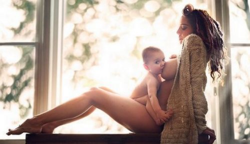 Mor sidder og ammer baby