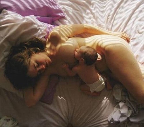 mor og baby sover i sengen