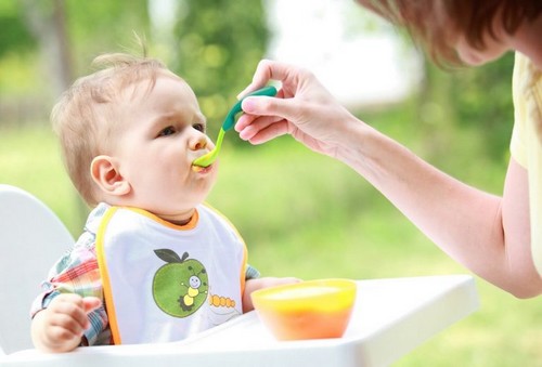 baby får puré med ske