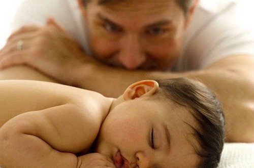 far kigger på sin nyfødte baby