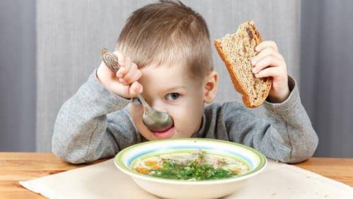 Barn spiser suppe med brød