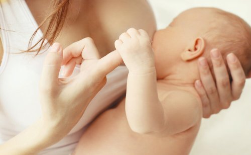 Ammende baby holder mors finger
