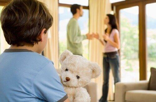 Forældre diskuterer foran dreng med bamse