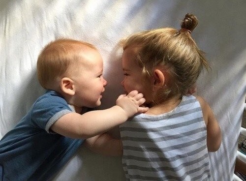 Glade søskende kigger på hinanden