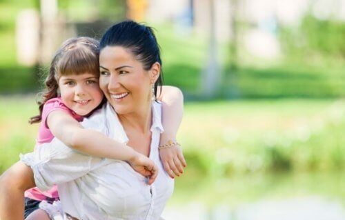 Smilende mor med datter på ryg