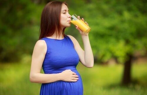 Gravid kvinde der drikker juice