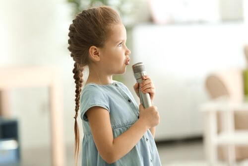 Pige synger ind i en mikrofon 