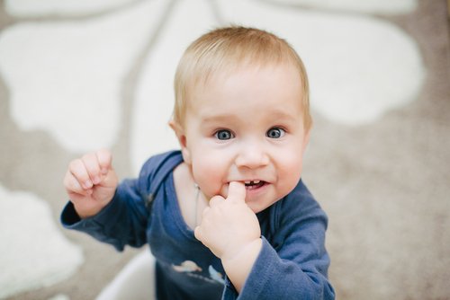 baby der sutter på sin finger