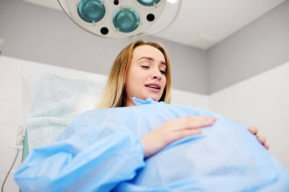 gravid kvinde i operationskittel