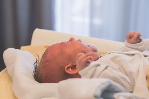 Baby græder i vugge og på puslebord
