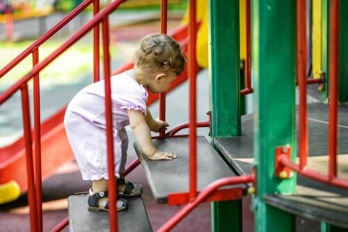 Baby kravler op ad trapper på legepladsen 
