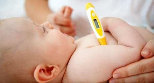 baby med termometer under arm