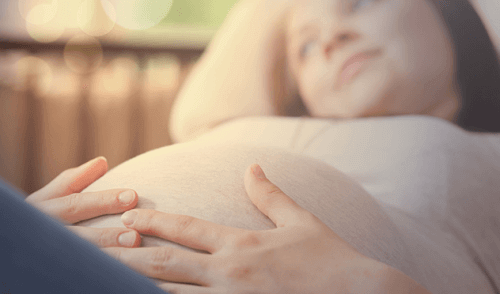 Gravid kvinde holder på sin mave
