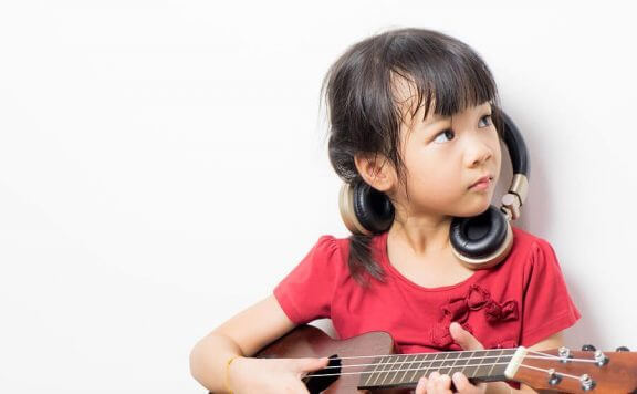 lille pige der spiller på guitar