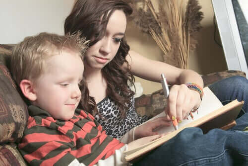 barnepige der hjælper dreng med at skrive