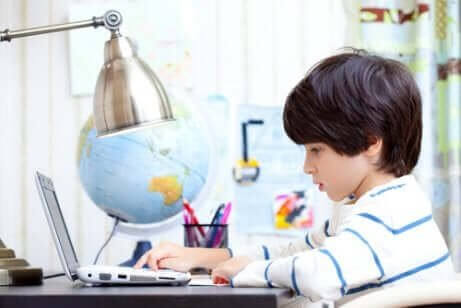 lille dreng der studerer på computer