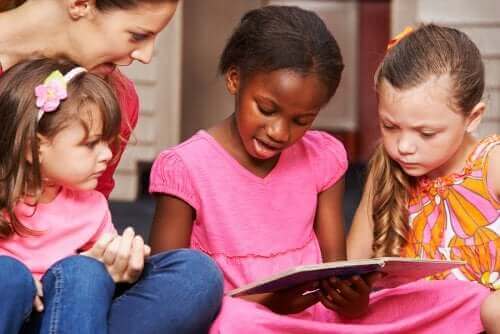 små piger der læser med voksen