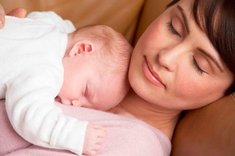 sovende mor med baby på sit bryst