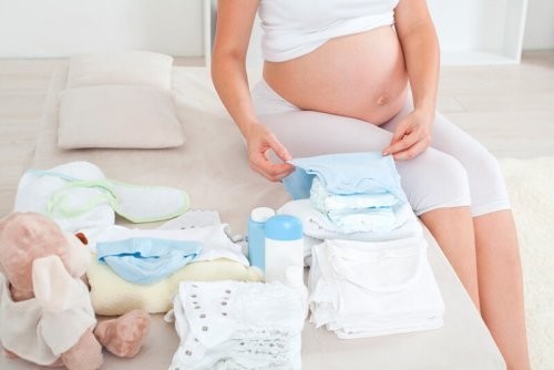 Gravid kvinde folder babytøj 
