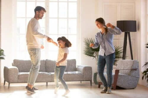 Far, mor og datter danser sammen i stuen