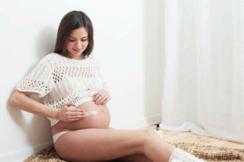 gravid der smører creme på sin mave