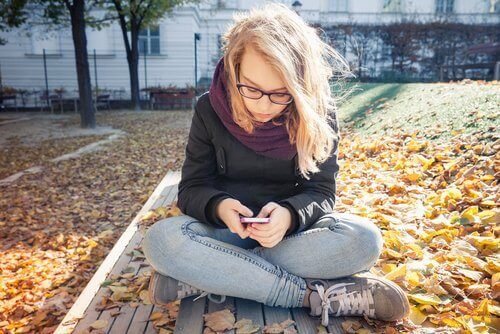 ung kvinde der bruger sin mobil udenfor