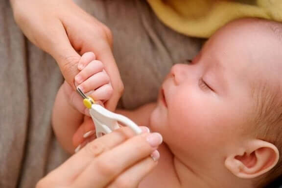 Baby får klippet negle.