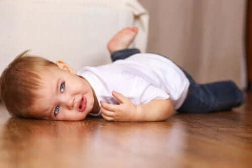 lille dreng der ligger på gulv