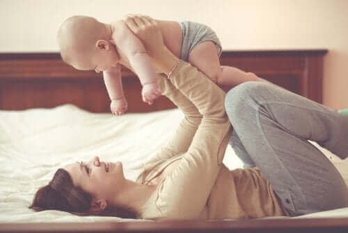 mor der leger med sin baby i seng