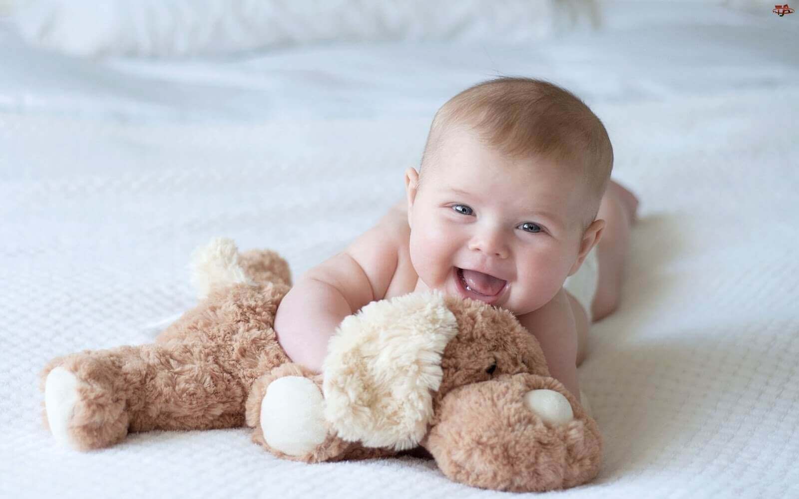 Dåbsgaveideer: Baby griner med bamse.
