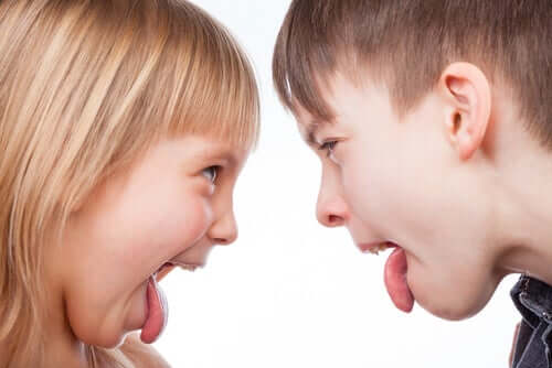 Børn rækker tunge af hinanden.