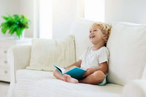 lille barn med bog i sofa