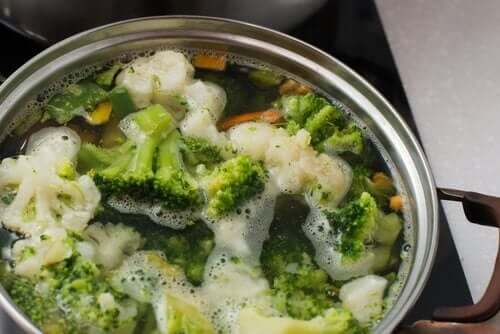 Lækre opskrifter med broccoli. Gryde med stykker af broccoli og blomkål, der koger i vand.