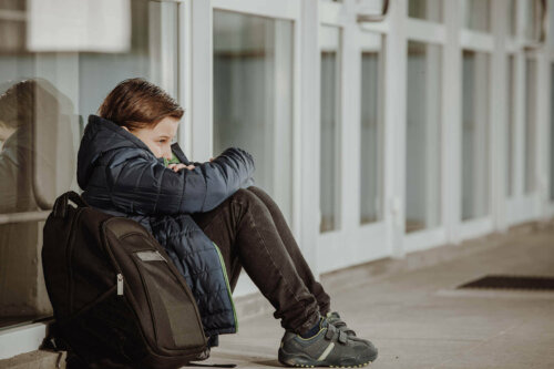 trist barn der sidder uden for skole