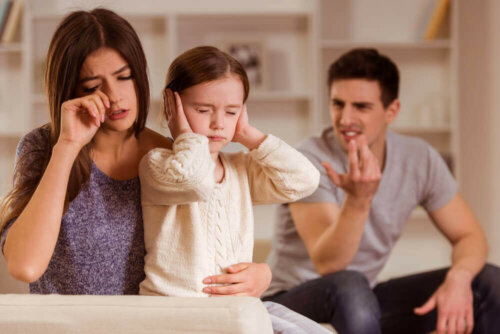 barn der holder sig for ørerne mens forældrene diskuterer