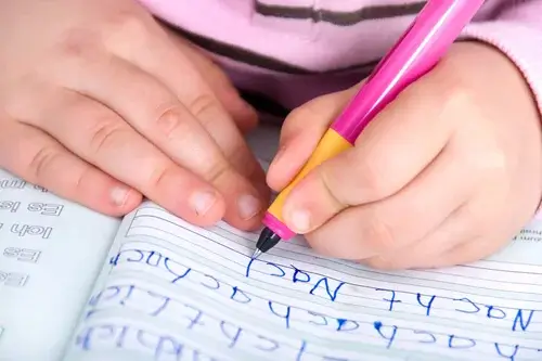 Barn skriver i hånden
