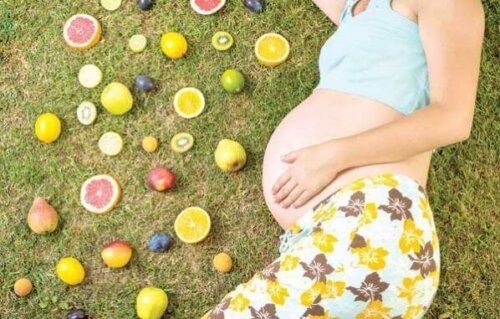 Gravid kvinde ligger med frugter på græs
