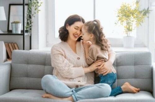 Mor og datter sidder sammen i sofa