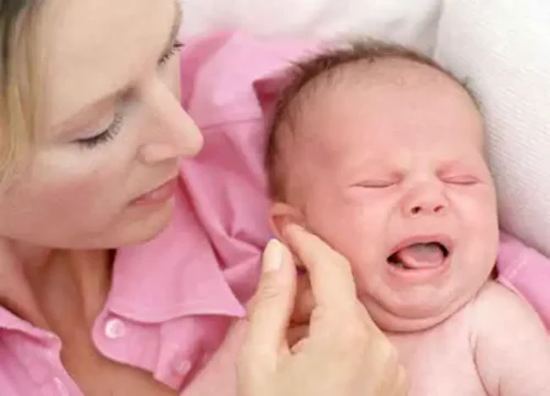 En baby græder og trøstes af mor