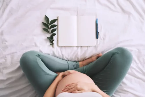 Gravid kvinde med bog vil skrive pigenavne med F