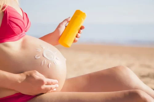 Kvinde påfører solcreme, som er en af de mest anbefalede cremer til gravide