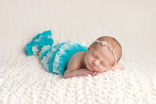 Baby klædt ud som havfrue symboliserer babynavne inspireret af havet